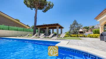 Privater Außenpool der Villa Paris mit blau gefliesten Rändern, mehreren Liegestühlen auf der Terrasse, einer überdachten Pergola und einem Steingrill im Hintergrund.