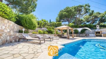 Privater Pool mit Sonnenliegen und Steinterrasse in der Villa Lorena, umgeben von Pinien, terrassierten Gärten und einem schattigen Pavillon.