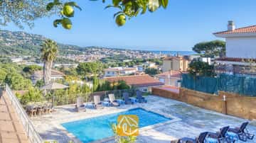 Privater Pool mit klarem blauen Wasser und umlaufenden Sonnenliegen mit Blick auf die Stadt und das Meer in der Villa Abigail